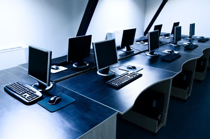 Computer bank with multiple Windows computers on desks