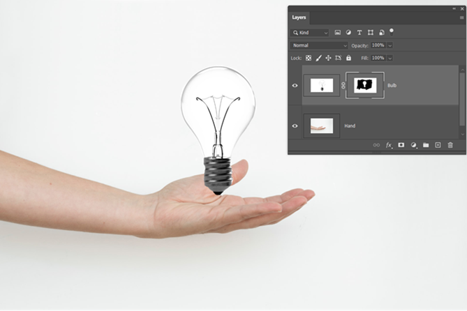 Слой Photoshop замаскированный изображением руки и лампочки